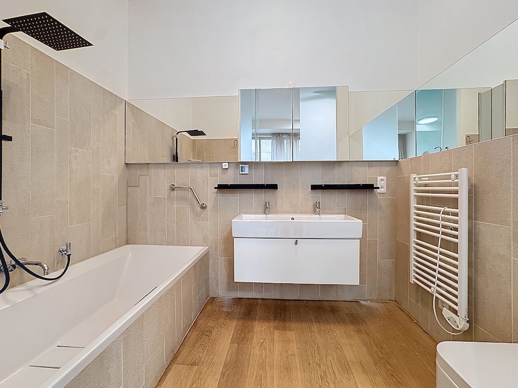 Salle de bain moderne avec baignoire, douche à pluie, double lavabo et design épuré