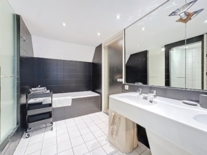 Salle de bain moderne en noir et blanc avec lavabo douche en verre baignoire et rangement stylé