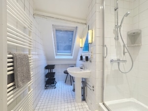 Salle de bain moderne minimaliste avec douche vasque murale radiateur et lumière naturelle