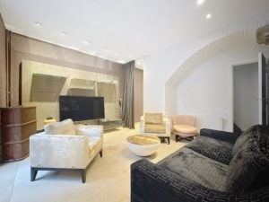 Salon moderne lumineux élégant avec canapé noir fauteuils pastel et décoration raffinée