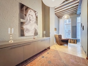 Salon moderne avec œuvre monochrome sol honeycomb chaud fauteuil cosy et touches rustiques