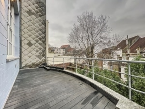 Balcon urbain moderne et nostalgique avec parquet courbé vue sur ville et ciel gris