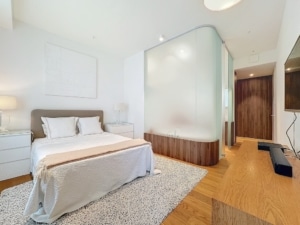 Chambre moderne avec lit queen cloison en verre semi transparente et décoration élégante