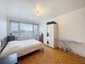 Chambre minimaliste moderne avec lit en bois grandes fenêtres et mobilier pratique