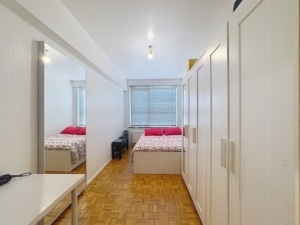 Chambre moderne lumineuse avec parquet clair lit coloré bureau blanc et rangements élégants