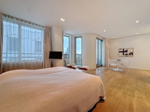 Chambre moderne lumineuse avec grand lit espace détente et décoration abstraite élégante