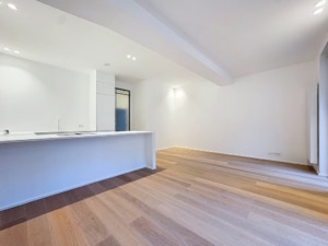 Cuisine moderne lumineuse avec îlot blanc sol en bois clair et ambiance épurée