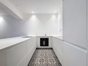 Cuisine moderne minimaliste avec armoires blanches éclairage encastré sol à motifs géométriques gris