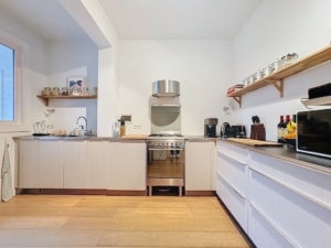 Cuisine moderne lumineuse minimaliste avec plans en bois et éclairage naturel idéale pour cuisiner