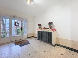 Entrée lumineuse avec portes en verre décoration florale et ambiance chaleureuse accueillante