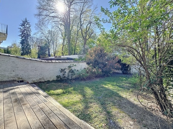 Terrasse en bois et jardin luxuriant sous un soleil doux parfait pour la détente extérieure