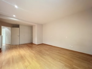 Espace intérieur lumineux et minimaliste avec parquet clair, murs neutres et rangement intégré.