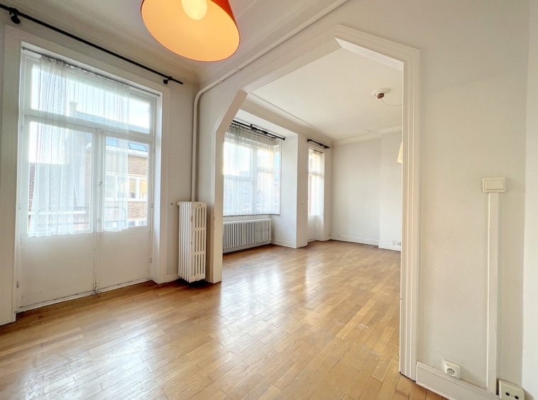 Appartement lumineux en style loft avec parquet chaleureux, murs neutres et décoration minimaliste élégante.