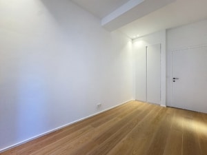 Intérieur minimaliste avec murs blancs sol en bois clair et éclairage doux moderne