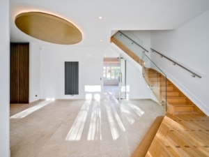 Intérieur moderne lumineux avec escalier en verre et bois design épuré et matériaux contrastés élégants