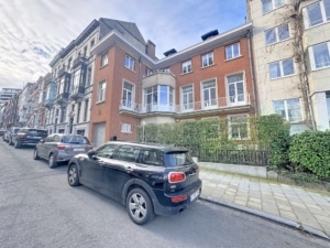 Rue urbaine charmante avec voitures modernes bâtiments en briques et façades en verre