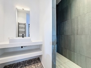 Salle de bain moderne avec contraste entre murs sombres sol élégants et espace lumineux