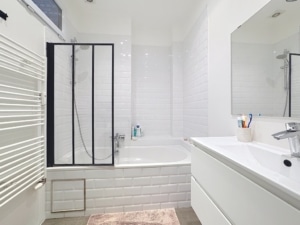 Salle de bain moderne minimaliste avec douche baignoire grand miroir et décor blanc et gris