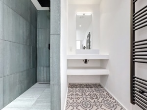 Salle de bain moderne avec douche gris texturé sol décoratif et meuble lavabo suspendu