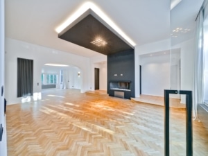Salon moderne lumineux avec parquet en chevrons cheminée design et grandes fenêtres