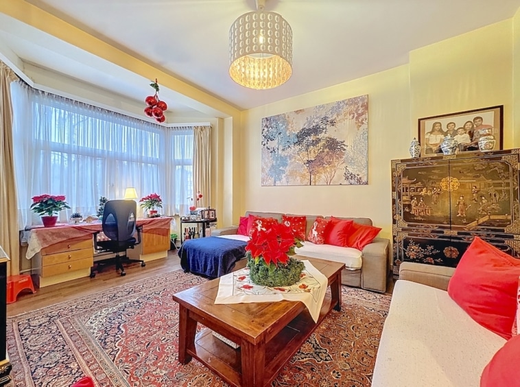 Salon cosy et élégant avec décoration festive, plantes, photos de famille et mobilier contemporain.