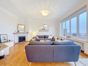 Salon moderne lumineux avec vue sur la nature canapé gris cheminée élégante et décoration chaleureuse