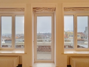 Salon lumineux avec grandes fenêtres vue urbaine décoration moderne ambiance élégante et accueillante