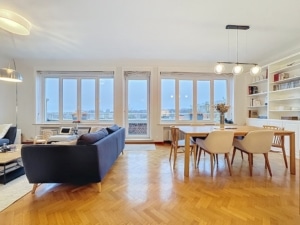 Salon lumineux moderne avec canapé bleu salle à manger en bois et vue naturelle