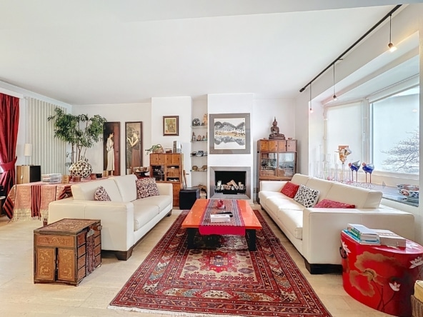 Salon élégant avec fauteuils blancs table rouge cheminée et décoration colorée chaleureuse