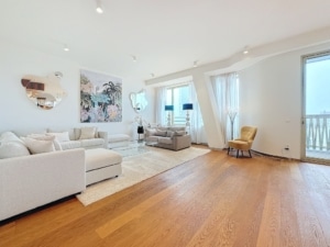 Salon moderne lumineux avec canapé fauteuils jaunes art floral et vue extérieure épurée