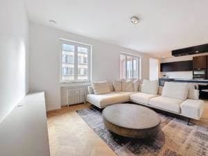 Salon moderne lumineux avec canapé beige mobilier épuré et vue urbaine