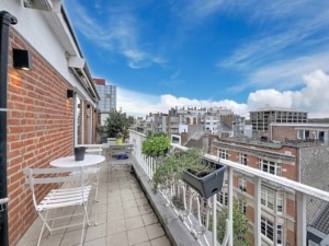 Balcon moderne avec vue sur une ville éclectique plantes vertes ciel bleu ambiance paisible