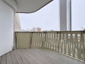 Balcon moderne en bois surplombant la ville urbaine avec gratte-ciel en verre.
