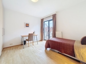 Chambre moderne et lumineuse avec parquet clair mobilier épuré et grande fenêtre apaisante