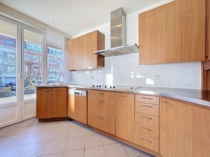 Cuisine moderne lumineuse avec bois clair plan blanc grandes fenêtres et appareils intégrés