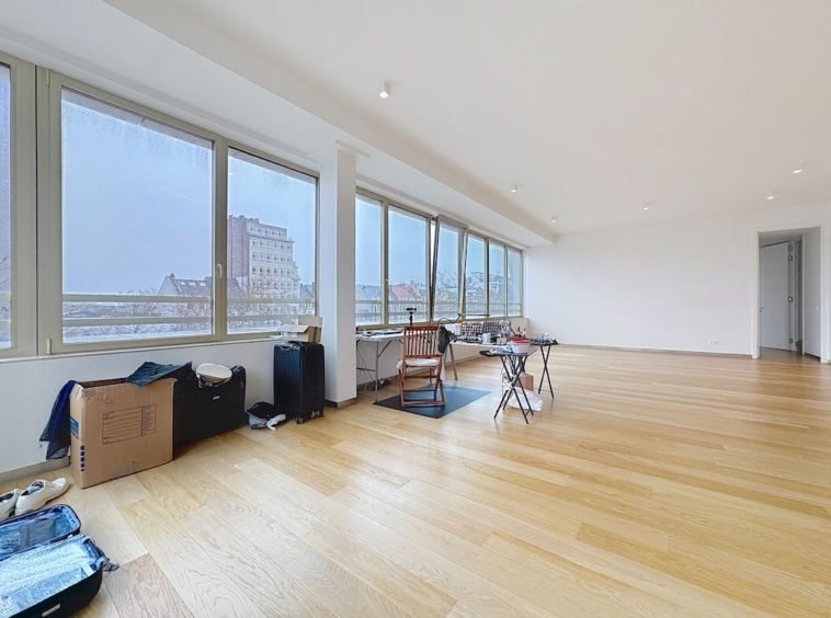 Espace lumineux et moderne avec grandes fenêtres, prêt à être personnalisé et aménagé.