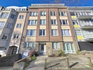 Immeuble résidentiel moderne en brique avec grandes fenêtres entrée centrale et jardin paysager