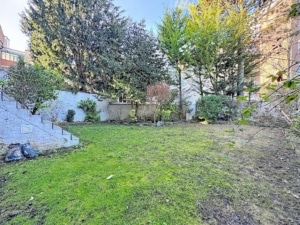 Jardin serein avec pelouse arbres escaliers en pierre et végétation luxuriante