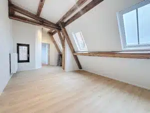 Loft lumineux avec poutres en bois grandes fenêtres et décoration moderne élégante