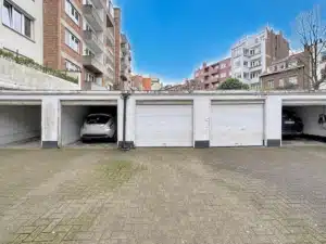 Parking résidentiel urbain avec garages immeubles en brique sous ciel bleu vie quotidienne en banlieue