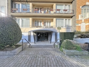 Résidence moderne avec balcon jardin soigné entrée élégante et contraste architectural en arrière plan