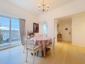 Salle à manger lumineuse avec table ronde chaises élégantes plantes et éclairage chaleureux