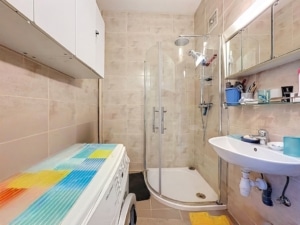 Salle de bain compacte moderne avec douche lavabo miroir machine à laver colorée ambiance lumineuse