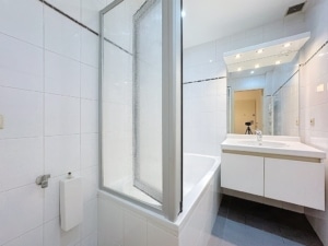 Salle de bain moderne minimaliste en blanc gris douche à verrière et meuble vasque éclairé