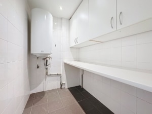 Salle de buanderie moderne lumineuse épurée avec meubles blancs et sol contrasté