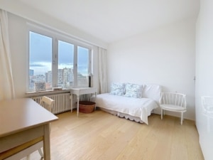 Salon moderne lumineux avec vue urbaine mobilier blanc décor pastel ambiance calme et élégante