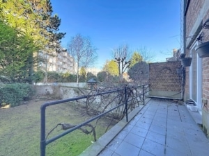 Terrasse paisible avec vue sur jardin verdoyant et ciel bleu idéale pour la détente