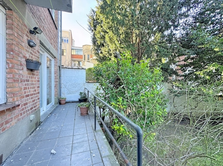 Chemin pavé, jardin urbain, ambiance paisible entre modernité et nature.