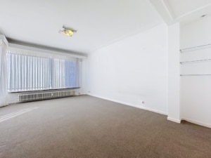 Espace lumineux minimaliste pour habitat ou bureau avec murs blancs grandes fenêtres étagères flottantes