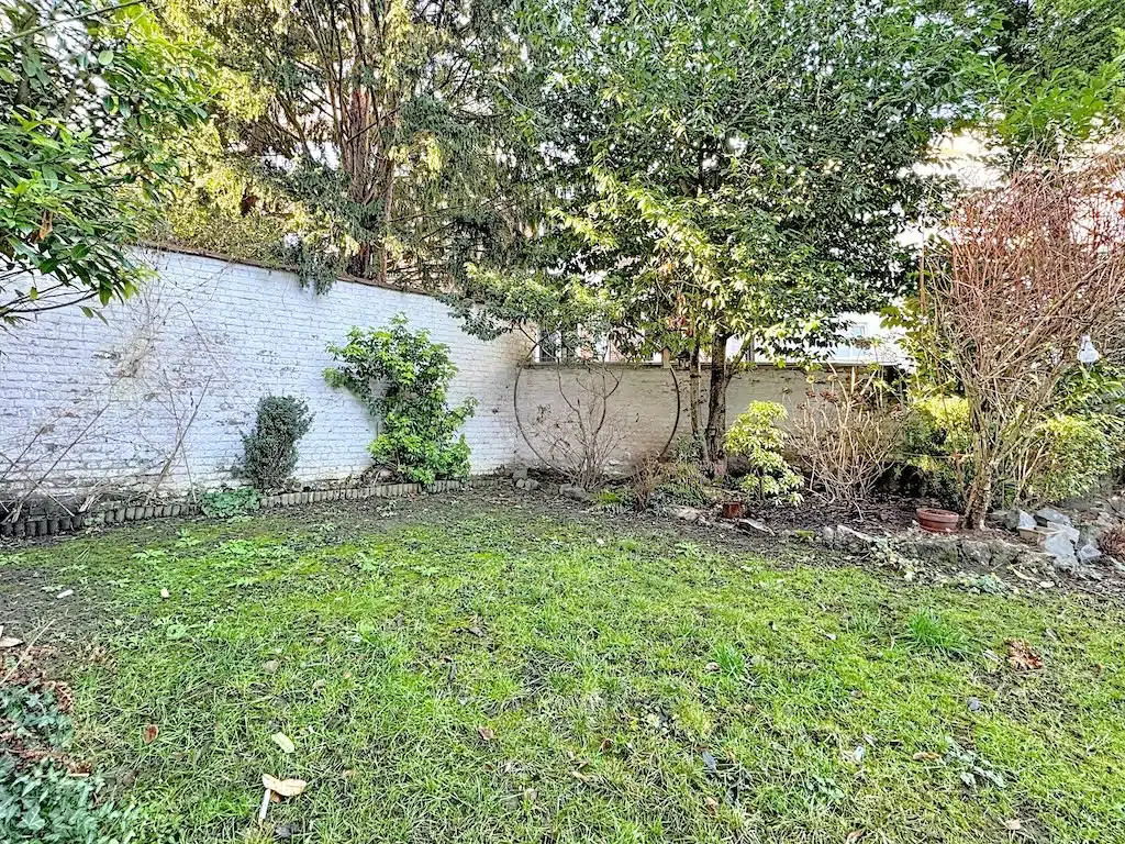 Peaceful garden with stone wall and lush vegetation Garden - Guy d'Arezzo : 2 bed apartment with garden - Uccle